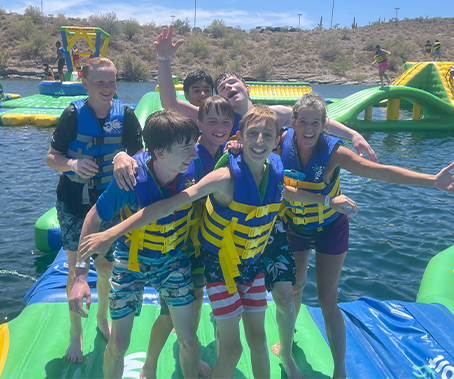 Teens playing on float at lake