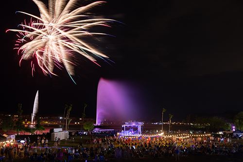 Fireworks over the lake at Fountain Park. The fountain is running in the foreground.